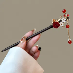 Exquisite Chinese style wooden hairpin detail, dark wood body, red rose and elegant tassel.