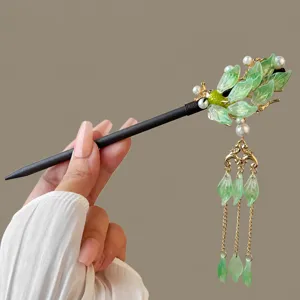 Detailed view of the handcrafted Chinese style wooden hair stick with green leaves.