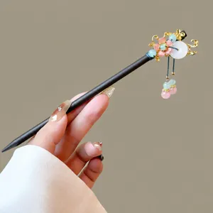 Traditional Chinese wooden hairpin with elegant floral metal tassel decor for elegant buns.