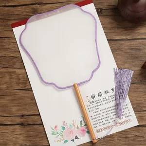 Traditional Chinese silk round fan detail close-up with wooden handle and purple tassel.