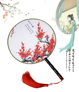 Détail de l'éventail rond chinois classique avec imprimé de prunier rouge et beau pompon.