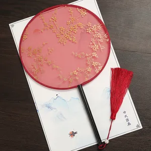 Éventail rond traditionnel chinois en tissu rouge avec motif floral doré et un gland