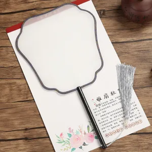 Detailed view of traditional Chinese blank round silk fan with elegant silver tassel trim.