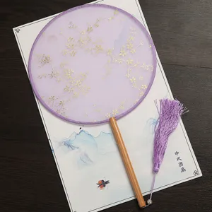 Éventail rond chinois traditionnel avec tissu violet, manche en bois et gland élégant.