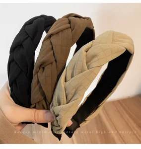 Vue détaillée du bandeau tressé en tissu avec texture raffinée pour un look élégant et chic.