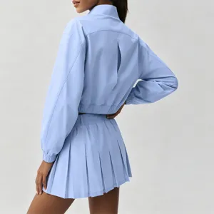 Light blue activewear set: cropped jacket with back vent and pleated tennis skirt.