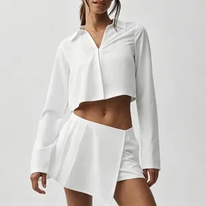 Ensemble haut court à manches longues et jupe-short plissée blanc, idéal pour sport et loisir.