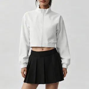 Details of white cropped athletic jacket and black pleated tennis skirt for outdoor fitness.