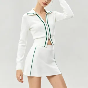 Gros plan sur le haut à manches longues en tricot contrasté et la jupe de tennis.