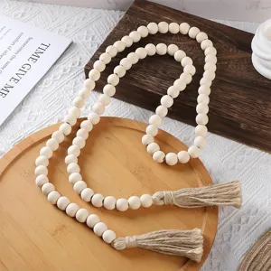 Detailed shot of rustic natural wood bead garland with hemp rope tassels for home decor.