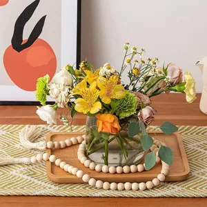 Rustic wooden bead garland with tassels styled in a cozy home decor scene detail shot.
