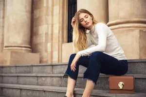 Ensemble elegant avec un haut en tricot blanc et un beau jean bleu pour femme mode.