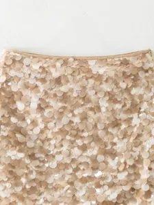 Close-up detail of a sparkly sequin skirt, showing shimmering beige paillettes and waistband.