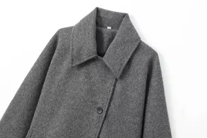 Détail revers manteau laine gris, texture douce, un bouton fermeture, élégant vêtement automne.