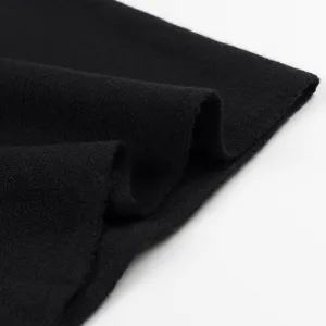 Nahaufnahme von schwarzem, fliessendem Strickstoff mit weicher Textur und feiner Webung.