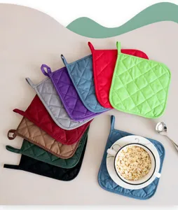 Gesteppte Topflappen aus Stoff in bunten Farben mit Aufhängeschlaufe für den Küchenschutz.