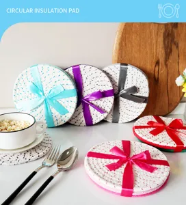 Detailed view of round cotton braided insulation pads decorated with colorful ribbon bows on table.