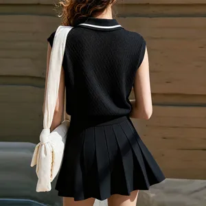 Détail de la vue arrière du haut polo sans manches en tricot noir et de la jupe plissée.