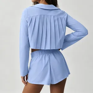 Détail arrière du haut court bleu clair à manches longues plissé et short assorti.