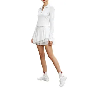 Ensemble haut polo femme manches longues blanc et jupe de tennis en tulle multicouche.