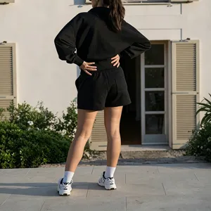 Detailed rear shot of black casual sports sweatshirt and shorts set worn outdoors.