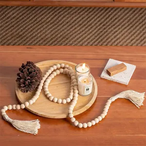 Detailed closeup of the rustic wooden bead garland with natural jute tassels on tray.