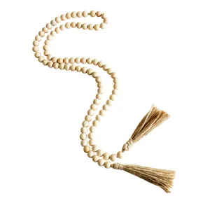 Wooden bead garland with jute tassels, natural rustic home decor handmade detail close up.
