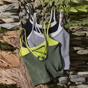 Detailed shot of ribbed knit sports crop top, featuring contrasting colors and crisscross straps.