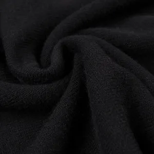 Nahaufnahme der schwarzen Strickstoff-Textur zeigt weichen Fall und feines Strickmuster.