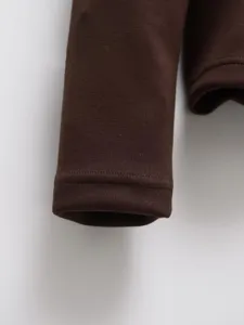 Brown women cotton jacket sleeve detail close-up, stylish winter outerwear fabric view.
