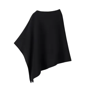 Detailaufnahme des schwarzen asymmetrischen Strickponchos, der weiche Drapierung zeigt.