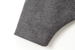 Gros plan sur le tissu du manteau en laine melangee grise, texture fine et toucher doux.
