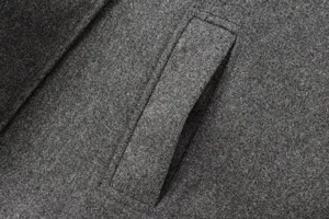 Détail de poche de manteau en laine grise, texture de tissu premium, couture exquise.