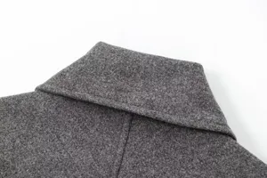 Vue détaillée d'un col de veste en mélange de laine gris foncé, tissu doux et finitions.