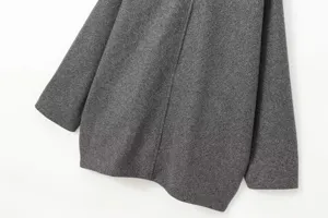 Vue de détail de la manche et de la couture du manteau gris, texture douce gros plan.