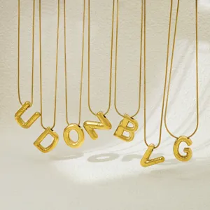 Gold balloon letter pendant necklace detail view, fashion metal initial jewelry for women.