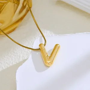 Gold bubble letter V pendant necklace close up shot sparkling delicate fashion jewelry accessory