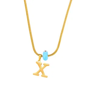 Gold snake chain necklace featuring an X letter pendant and a cute blue evil eye charm detail.