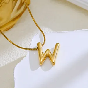 Gold bubble letter W pendant necklace close up, stylish fashion jewelry accessory for women.