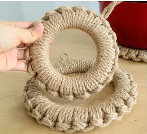 Detalle de agarradera de cuerda de yute hecha a mano, salvamanteles redondo natural.