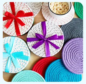 Detailed shot of colorful braided cotton coasters and placemats on wooden table, heat insulated.