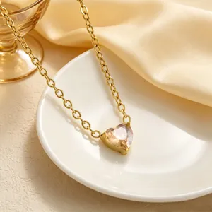 Primo piano di collana con ciondolo in cristallo a forma di cuore su piatto bianco, dettaglio.