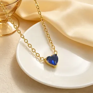 Vista dettagliata di una collana placcata in oro con ciondolo in zircone blu a cuore elegante.