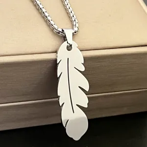Stainless steel feather pendant necklace detail, silver box chain close up jewelry view.