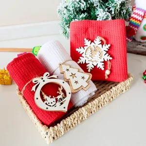 Set di strofinacci da cucina natalizi in tessuto waffle con decori in legno nel cestino.
