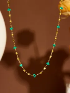 Squisita collana girocollo dorata impreziosita da pietre di cristallo verde e cubi metallici.