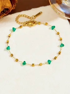 Bracciale a catena dorata con perline di cristallo verde e cubi metallici stile alla moda.