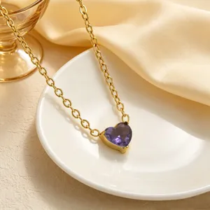 Primo piano dettagliato della collana con ciondolo in pietra preziosa a cuore viola su piatto.
