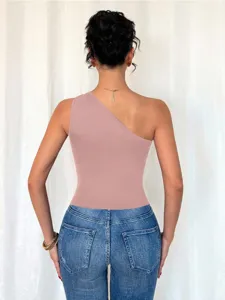 Λεπτομερής λήψη του κομψού ροζ ασύμμετρου τοπ χωρίς μανίκια συνδυασμένου με μπλε τζιν.
