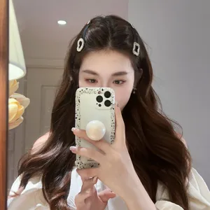 Vue détaillée de l'élégante pince à cheveux en strass en forme de cœur portée sur des vagues.